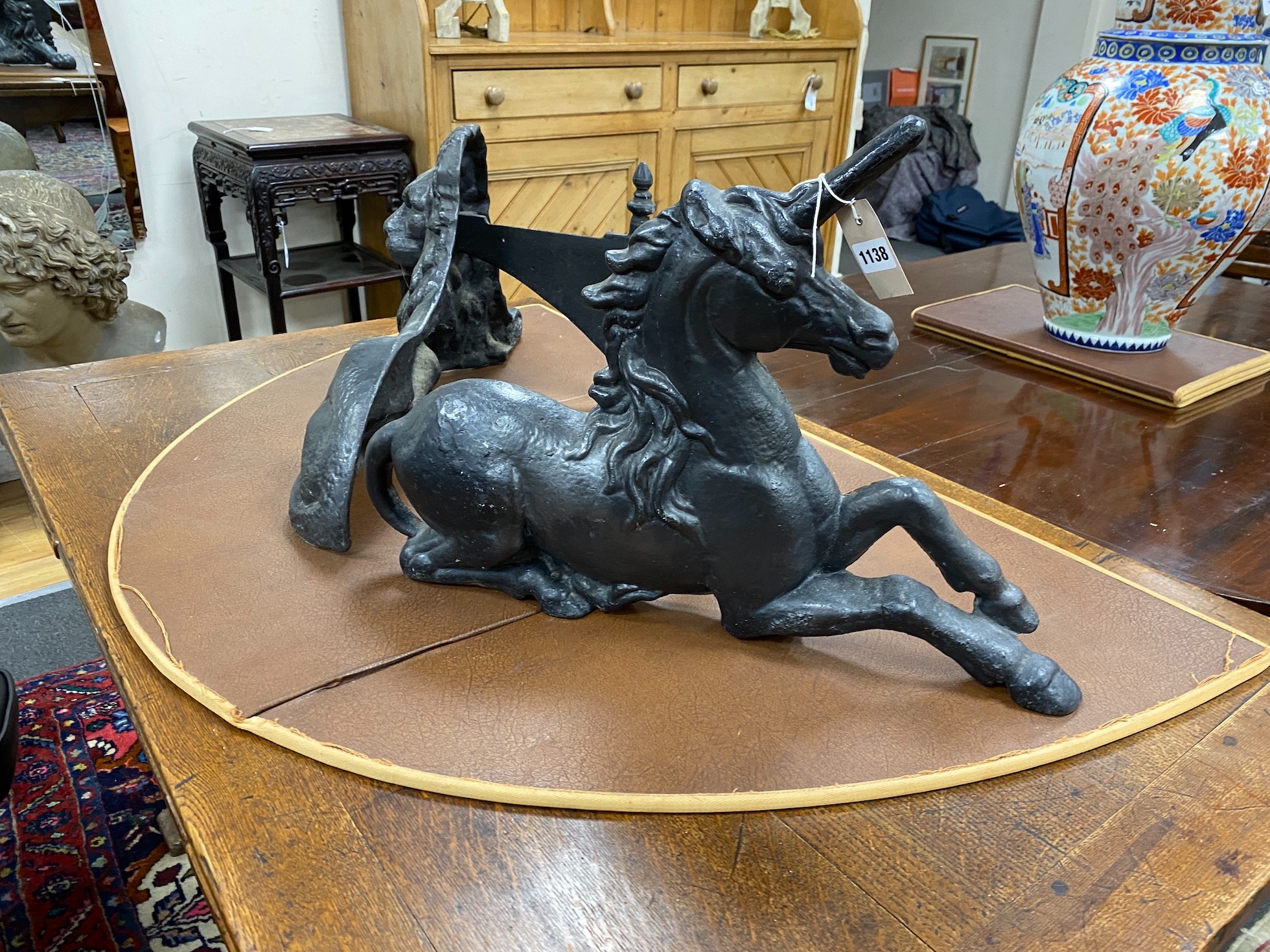 Two cast iron fire ornaments modelled as heraldic lion and unicorn, width 62cm